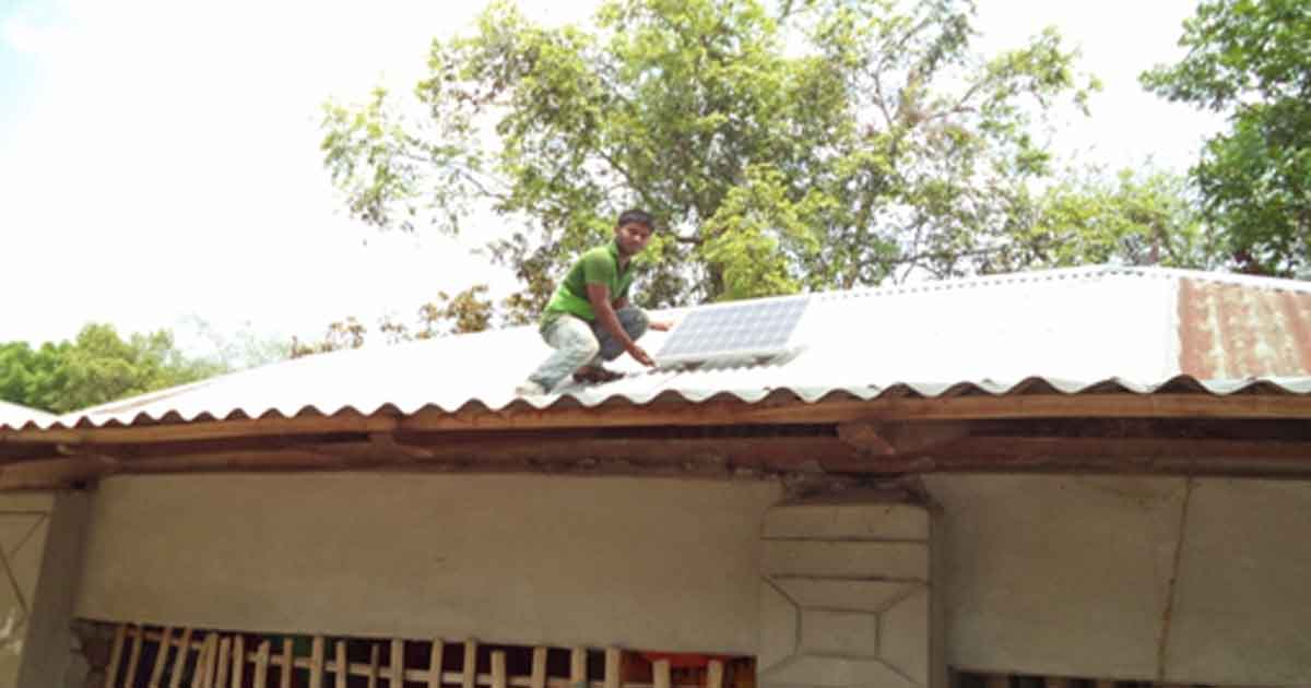 A staff is setting a solar Home System (SHS)